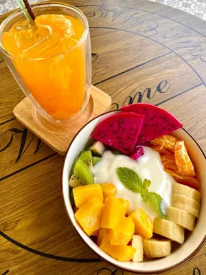a bowl of fruit and a drink on a table at Kata Luxury Apartment Matriochka 2BR En-suite in Kata Beach