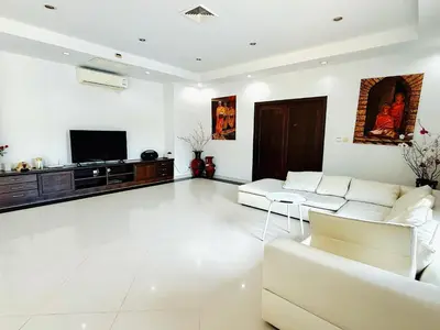 a living room with white furniture and a flat screen tv at Chuan Pool Villa Rawai Phuket in Rawai Beach