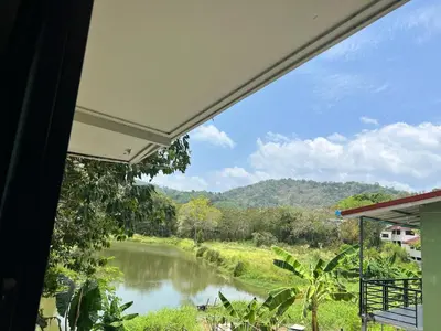 a view of a river from a house window at Chill Apartment Lake View in Rawai Beach