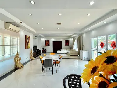 a dining room and living room with a table and chairs at Chuan SeaFront Villa Rawai Phuket in Rawai Beach
