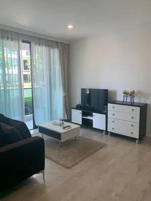 a living room with a couch and a tv at Royal Lee Phuket Condominium AirportB in Ban Bo Han
