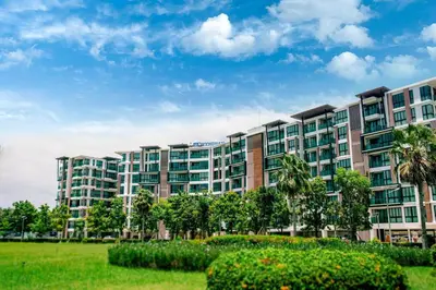 a large apartment building with a park in front at Royal Lee Phuket Condominium AirportB in Ban Bo Han
