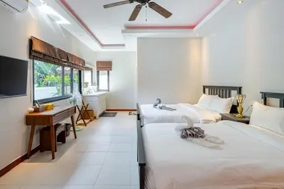 a bedroom with three beds and a desk and a desk at Lantern Villa Private Pool Villa in Ban Klang