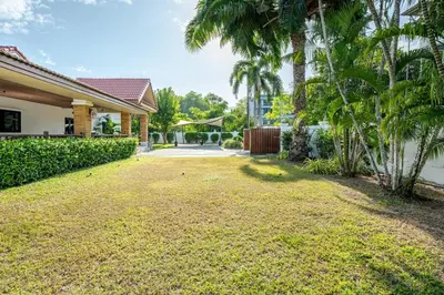 an empty yard in front of a house with palm trees at Lantern Villa Private Pool Villa in Ban Klang