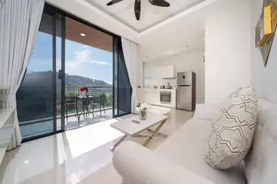 a living room with a white couch and a table at Sea & Mountain Views Apartment A602 at VV Patong in Patong Beach