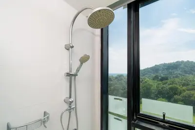 a shower in a bathroom with a window at Sea & Mountain Views Apartment A602 at VV Patong in Patong Beach