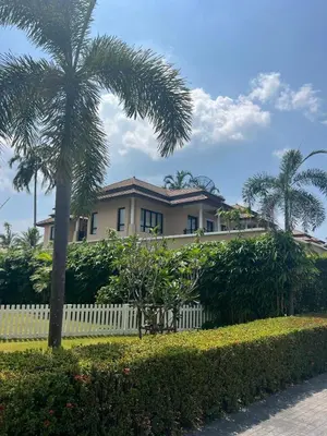 a house with a white fence and palm trees at Villa Laguna Bang Tao in Laguna Phuket