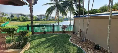 a backyard with palm trees and a fence at Villa Laguna Bang Tao in Laguna Phuket