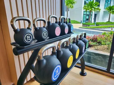 a row of dumbbells on a rack in front of a window at New Studio in 5 Hotel 500m to Rawai beach in Phuket Town
