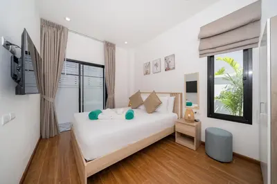 a bedroom with a white bed and a window at Goldena Twin Project - 3 Bedrooms Pool Villa in Kamala Beach