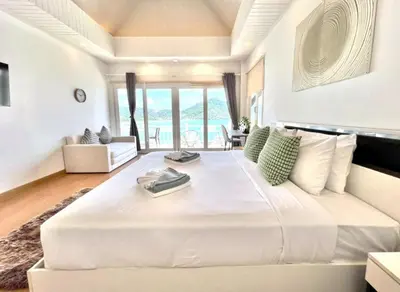 a large white bedroom with a large white bed at Jaokhun Bayview Kamala, Phuket in Kamala Beach