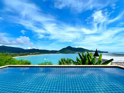 a swimming pool with a view of the ocean at Jaokhun Bayview Kamala, Phuket in Kamala Beach