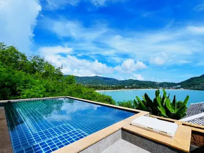 a swimming pool with a view of the water at Jaokhun Bayview Kamala, Phuket in Kamala Beach