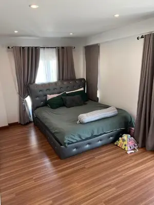 a bed in a room with a leather couch at Villa PalmSprings in Ban Phak Chit