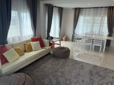 a living room with a white couch and a table at Villa PalmSprings in Ban Phak Chit