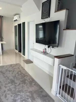 a living room with a flat screen tv on a wall at Villa PalmSprings in Ban Phak Chit