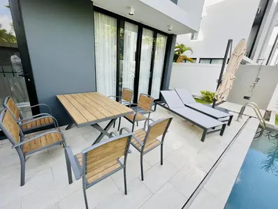 a patio with a table and chairs and a pool at 3bdr Pool Villa Laguna Park-2 in Ban Phru Champa