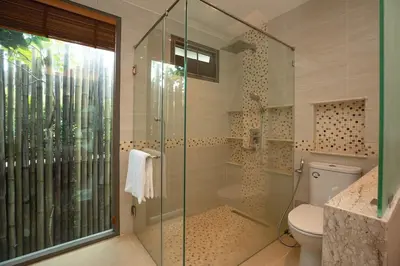 a bathroom with a glass shower with a toilet at Luxury 5 Bedroom Staffed Botanica Villas in Ban Phru Champa