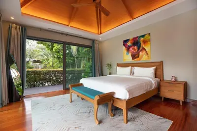 a bedroom with a large bed and a large window at Luxury 5 Bedroom Staffed Botanica Villas in Ban Phru Champa