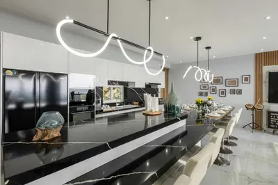 a kitchen with a long counter with a long table at Seaview three bedroom villa in Bangtao area in Ban Thalat Choeng Thale