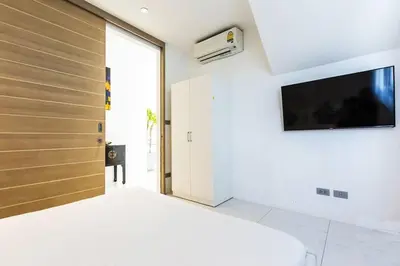 a bedroom with a bed and a flat screen tv at The View Phuket F9 in Kata Beach