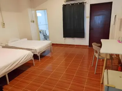 a room with two beds and a wooden floor at XX GO INN Phuket Patong Beach in Patong Beach