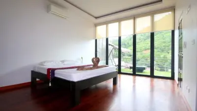a bedroom with a bed and a large window at Villa Loma & Patong 6 chambres in Patong Beach