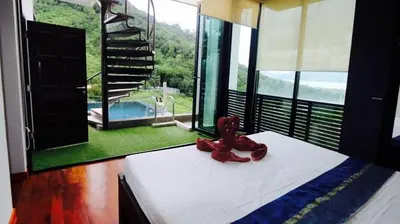 a bed with a pair of shoes on top of it at Villa Loma & Patong 6 chambres in Patong Beach
