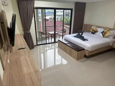 a bedroom with a bed and a balcony at Sumaka Hotel Karon in Kata Beach