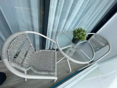 a white chair and a table and a plant in a window at Laya Residence Memoory Layan in Ban Na Bon