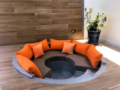 a circular couch with orange pillows in a living room at 20 - Tranquil Retreat near Marriott Naiyang Beach in Nai Yang Beach
