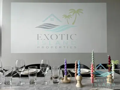 a table with wine glasses and a sign that reads exotic island properties at Stylish 3BR Private Pool Villa Bangtao Beach in Ban Pak Lak