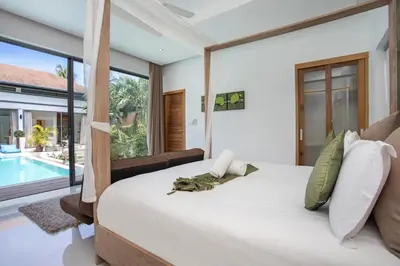 a bedroom with a large bed and a swimming pool at Luxury 4BR Villa Virginie, Salt Pool, Rawai in Rawai Beach