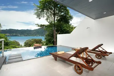 a view of a pool from a house with a wooden cart at Atika Villa 7 ocean view pool villa in Patong Beach