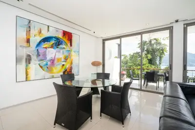 a dining room with a glass table and chairs at Atika Villa 7 ocean view pool villa in Patong Beach