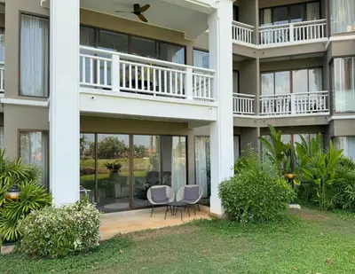 an exterior view of a building with two chairs at Private apartment at Allamanda II by Lofty in Bang Tao Beach