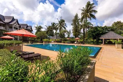 a pool at a resort with chairs and umbrellas at Private apartment at Allamanda II by Lofty in Bang Tao Beach