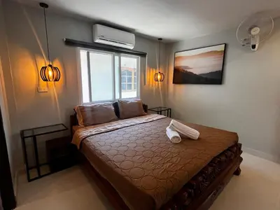 a bedroom with a bed and a window at Newly Renovated Sea View House in Karon Beach