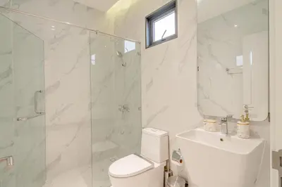 a bathroom with a toilet and a glass shower at Bang Tao Luxury Villa - Menara Hill in Ban Phak Chit
