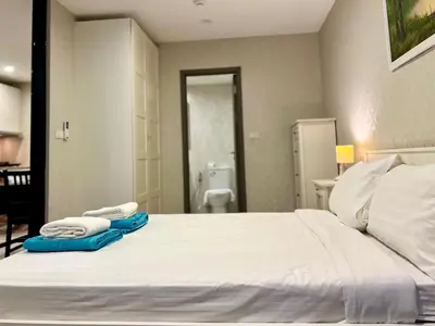 a bedroom with a large white bed with towels on it at The Title NaiyangPhuket1 in Phuket