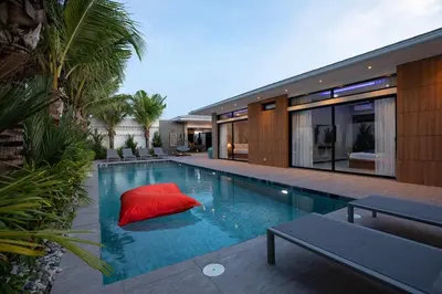 a swimming pool with a red pillow in a house at Stunning 4 bedrooms pool villa at Rawai kokmakham 2 in Rawai Beach