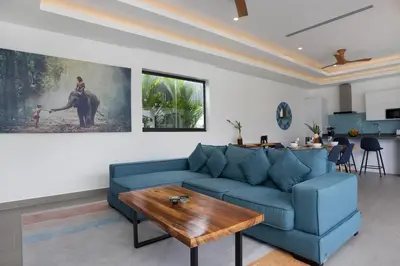 a living room with a blue couch and a table at Two-Bedroom Villa with Salt Pool in Rawai villa hapai in Rawai Beach