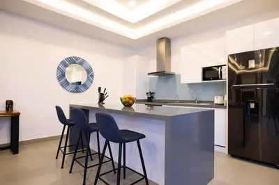 a kitchen with a counter and stools in a room at Two-Bedroom Villa with Salt Pool in Rawai villa hapai in Rawai Beach