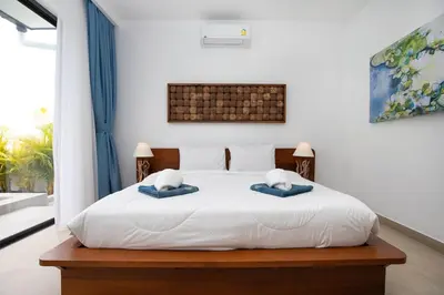 a bedroom with a white bed with two pillows on it at Villa Malaki, pool villa 2 bedrooms at rawai in Rawai Beach