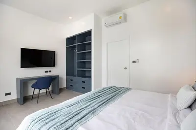 a bedroom with a bed and a desk with a television at Sumptuous 4 bedroom pool villa at rawai beach RB 2 in Rawai Beach