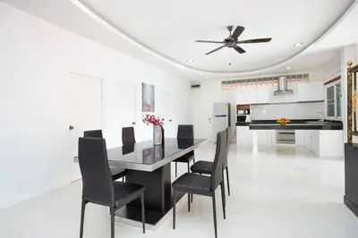 a kitchen and dining room with a table and chairs at Family Holiday 3BR Pool Villa Lancelot 2 in Rawai Beach