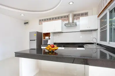 a kitchen with a counter with a bowl of fruit on it at Family Holiday 3BR Pool Villa Lancelot 2 in Rawai Beach