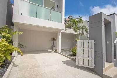 an exterior view of a white house with a driveway at Private 4BR Pool Villa Skylight with Stunning Views of Kamala Green Hills in Kamala Beach