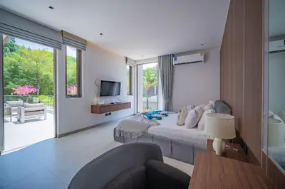 a bedroom with a bed and a couch and a television at Grand View Residence Villa by NLA in Bang Tao Beach