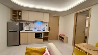 a kitchen with a stainless steel refrigerator and a table at Premium 2BR near Kamala Beach, Pool, Gym & Shuttle Bus in Phuket Town